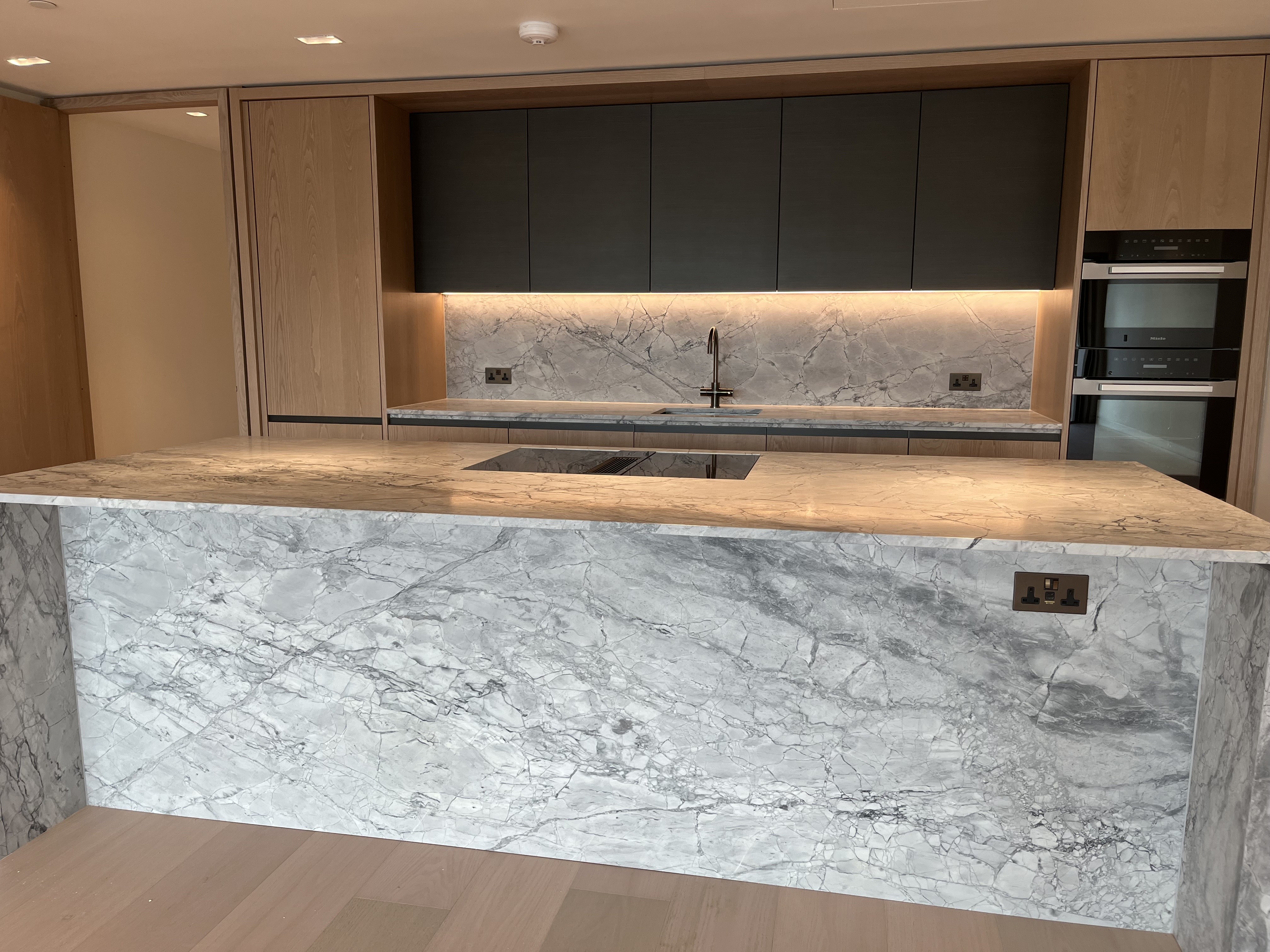 Tiler installing ceramic tiles in London kitchen